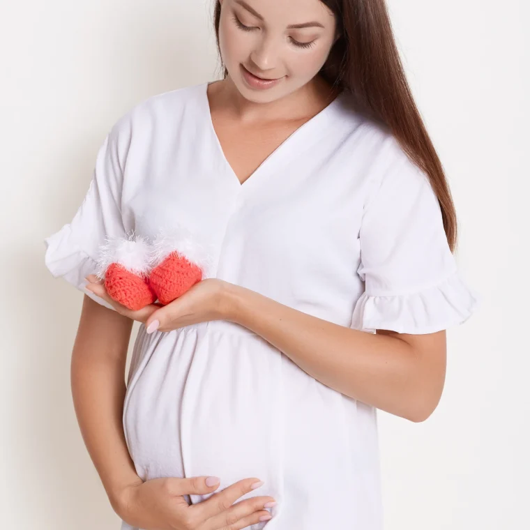 gently-pregnant-woman-with-red-booties-touching-her-belly.jpg